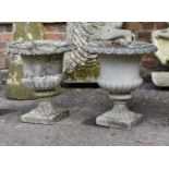 A pair of composition stone urns