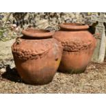 A large pair of terracotta twin handled garden urns