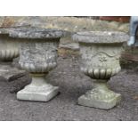 A pair of composition stone urns