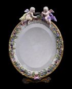 A Meissen flower encrusted and gilt metal mounted oval strut looking glass