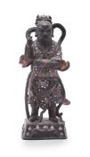 A Chinese lacquer and mother of pearl inlaid figure of a Deity