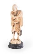 Y A Japanese Ivory Okimono carved to represent a mendicant priest