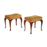 A pair of mahogany and upholstered stools