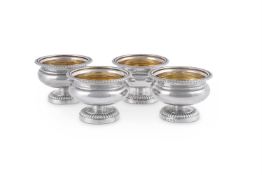 A SET OF FOUR GEORGE III CIRCULAR PEDESTAL SALT CELLARS BY PAUL STORR