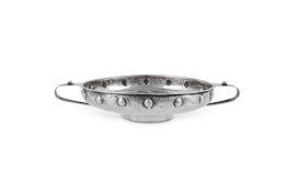 AN ARTS AND CRAFTS HAMMERED SILVER CIRCULAR TWIN HANDLED BOWL BY A.E JONES (ALBERT EDWARD JONES)