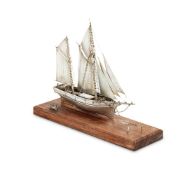 A SILVER MODEL OF A TWO-MASTED WOODEN SAILING SHIP