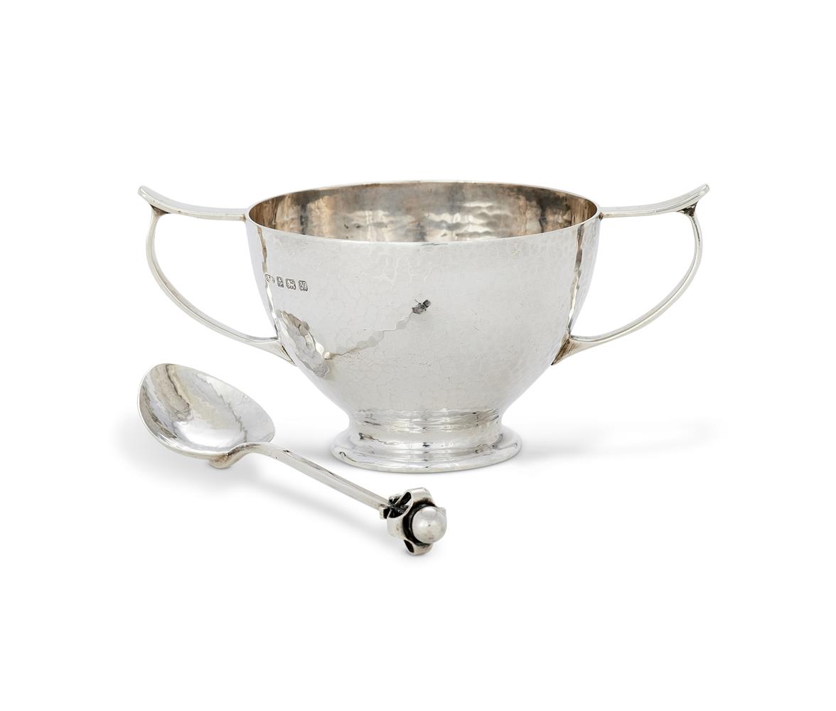 AN ARTS AND CRAFTS HAMMERED SILVER CHRISTENING BOWL AND SPOON BY A.E JONES (ALBERT EDWARD JONES)