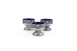 A MATCHED SET OF THREE GEORGE III SILVER OVAL PEDESTAL SALT CELLARS BY ROBERT HENNELL I