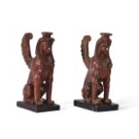 A NEAR PAIR OF CARVED AND RED LACQUERED SPHINXES, 19TH CENTURY