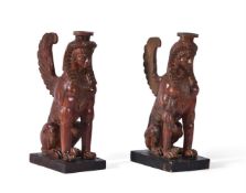 A NEAR PAIR OF CARVED AND RED LACQUERED SPHINXES, 19TH CENTURY
