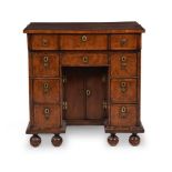 A QUEEN ANNE WALNUT AND FEATHERBANDED KNEEHOLE DESK, CIRCA 1710