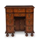A QUEEN ANNE WALNUT AND FEATHERBANDED KNEEHOLE DESK, CIRCA 1710