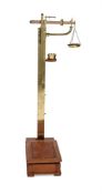 AN EDWARDIAN OAK AND BRASS PERSONAL WEIGHING SCALES BY W. & T. AVERY LTD, CIRCA 1910