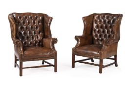 A PAIR OF MAHOGANY AND BUTTONED LEATHER UPHOLSTERED WING ARMCHAIRS, IN GEORGE III STYLE