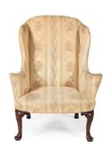A GEORGE II WALNUT AND UPHOLSTERED WING ARMCHAIR, CIRCA 1740