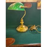 Brass based desk lamp with green glass shade.