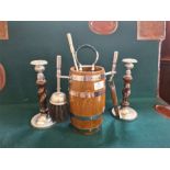 An oak coopered barrel fireside companion set and a pair of barley twist and chromium candlesticks.