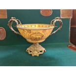 Large brass mounted pottery fruit bowl with ruined temple panels and foliate handles. 46cm wide.