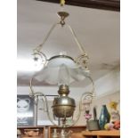Victorian hanging oil lamp with decorative brass frame and milk glass frilled shade.