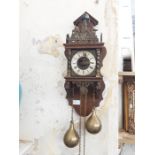 Modern twin brass weight wall hanging clock with cast brass figural decoration and silvered dial.