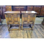 A pair of Old Charm oak 2 door linen fold night stands.