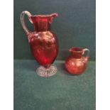 Large Victorian cranberry glass jug with clear cut foot standing 11" tall and a similar smaller