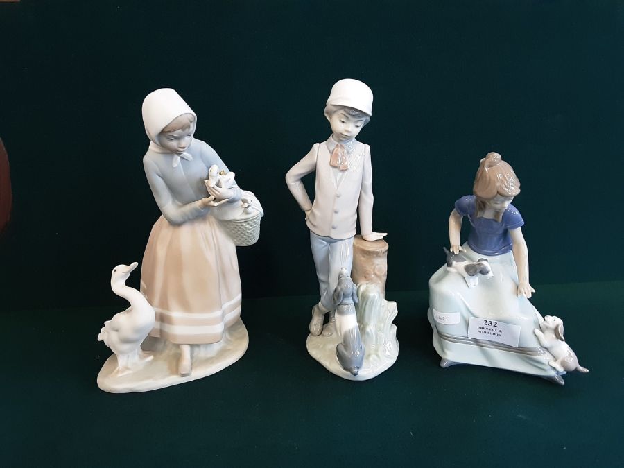 A pair of Lladro/Nao figurines Girl with puppies and Boy and his dog together with a Lladro figure