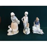 A pair of Lladro/Nao figurines Girl with puppies and Boy and his dog together with a Lladro figure