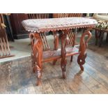 A carved Indian teak 6 leg occasional table.
