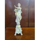 Continental porcelain figurine of a young robed girl carrying flowers stood on an orb on lions paw