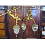 A pair of gilt plaster cherub angel hanging chandeliers with crystal bag drops and a further similar