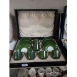 A cased Royal Austria green coffee set with sterling silver decoration.
