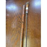 A carved bamboo sword stick with white metal tip and collar (damaged).