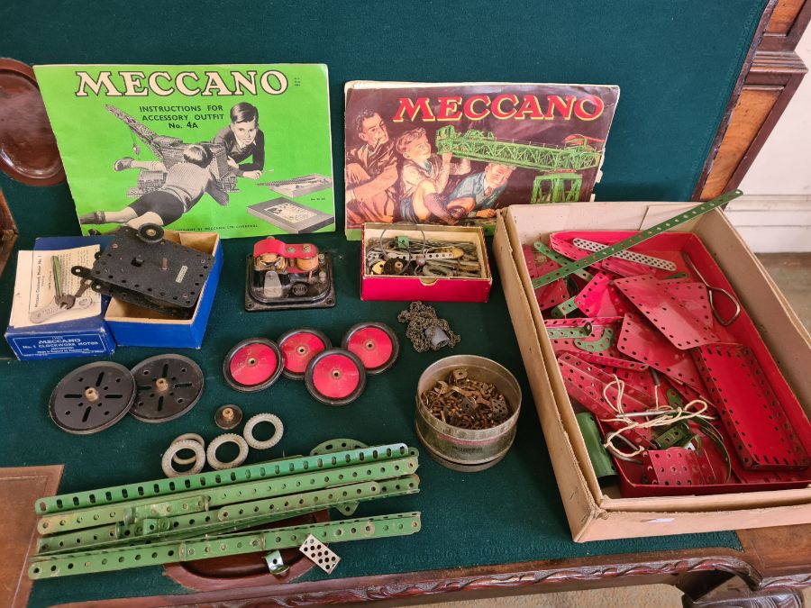 A mixed lot of vintage Meccano including clockwork and electric motors, fittings, wheels red and