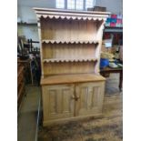 Reclaimed polished pine dresser with panelled door base and arcaded plate rack, 111cm wide x 184cm