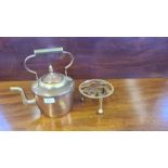 Modern copper and brass hammered kettle and a brass trivet.