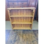 Reclaimed polished stripped pine bookcase on bun feet.