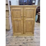Stripped pine panelled 2 door cupboard with fitted shelves, 99cm wide x 131cm tall x 37cm deep.