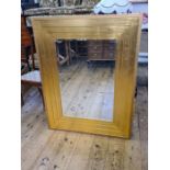 A large gilt geometric framed wall hanging bevel edged mirror, 130cm x 100cm.