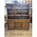 Early 20th century oak sliding door housekeepers cupboard with upper glazed sliding doors.