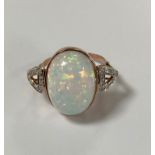 BAGUE en or rose ornée d'une opale cabochon sertie clos (8 cts environ) épaulée de dix-huit petits