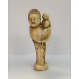 NETSUKE en ivoire sculpté figurant une jeune femme debout, ses cheveux coiffés en chignon fleuri,