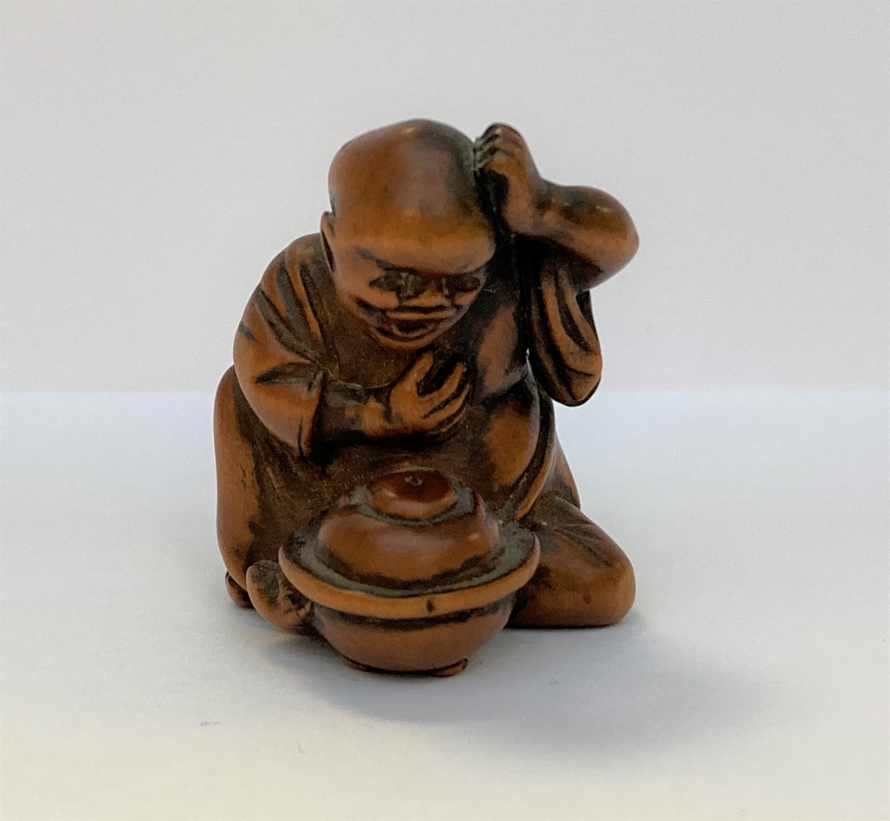 NETSUKE en buis illustrant la légende bunbuku chagama, le moine observant sa bouilloire se