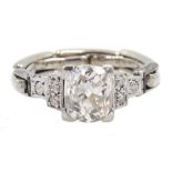 Art Deco platinum diamond ring, the central cushion cut diamond of approx 1.10 carat, with three dia