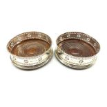 Matched pair of silver bottle coasters with pierced decoration and turned mahogany bases D13cm Birmi