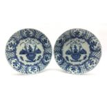 Pair of 18th century Delft blue and white chargers, centrally painted with a vase of flowers, the bo