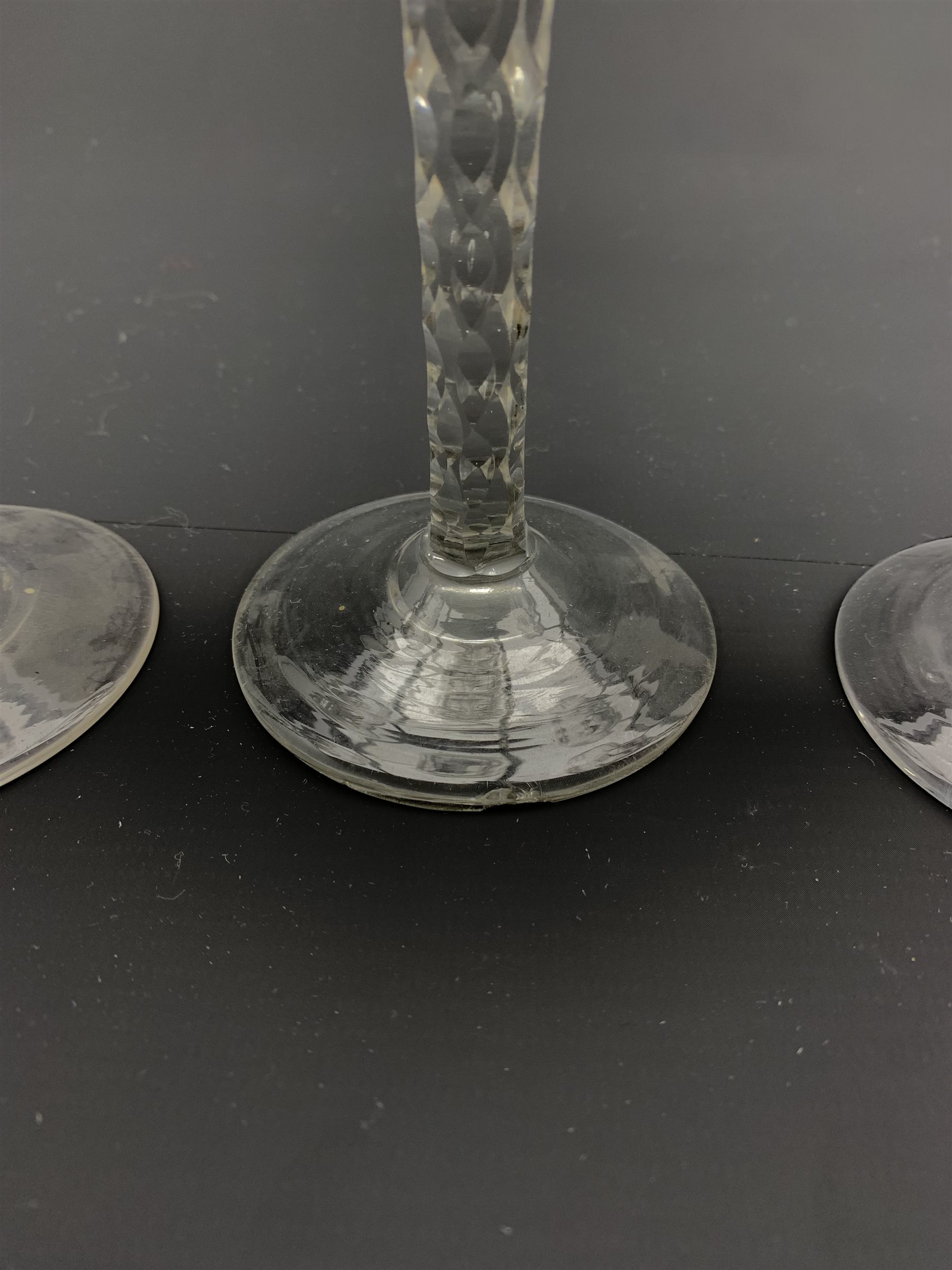 Set of three 18th century wine glasses, the ovoid bowls engraved with flower sprigs on faceted stems - Image 3 of 4