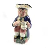 Pratt Type pottery toby jug of traditional form holding a cup and jug on a sponge base, H26cm