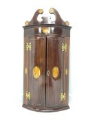 Early 20th century inlaid mahogany bow front corner cabinet, swan neck pediment above two doors encl