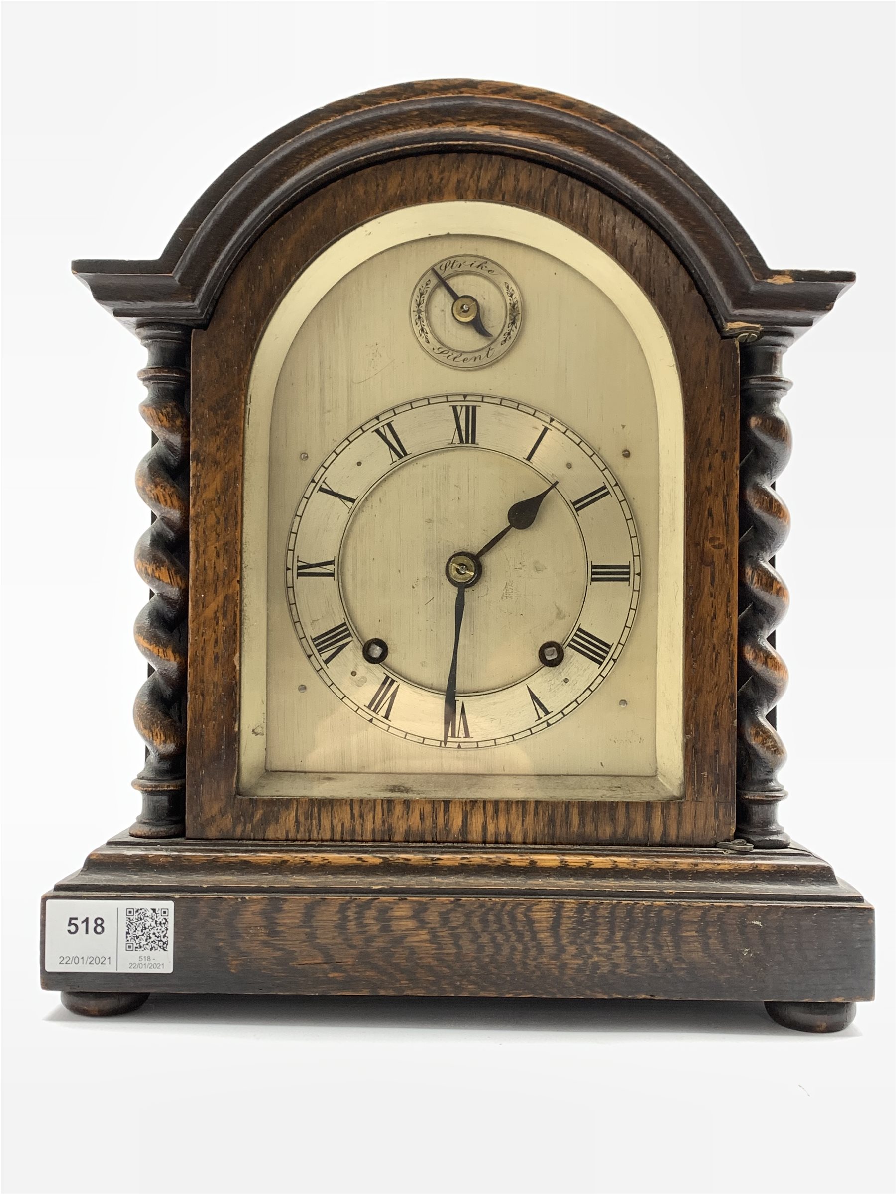 Early 20th century oak cased mantel cock, domed top over spiral turned pilasters and stepped base ra